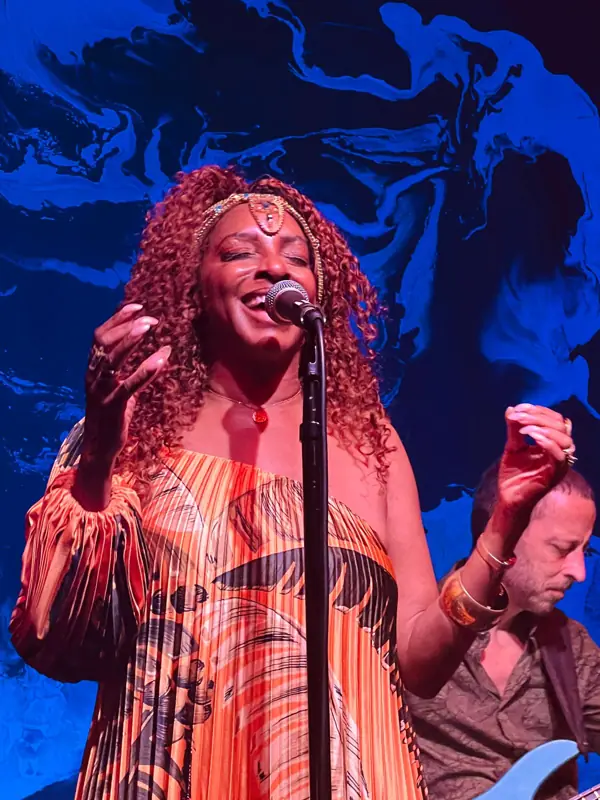 Kandace Lindsey singing in front of a blue backdrop
